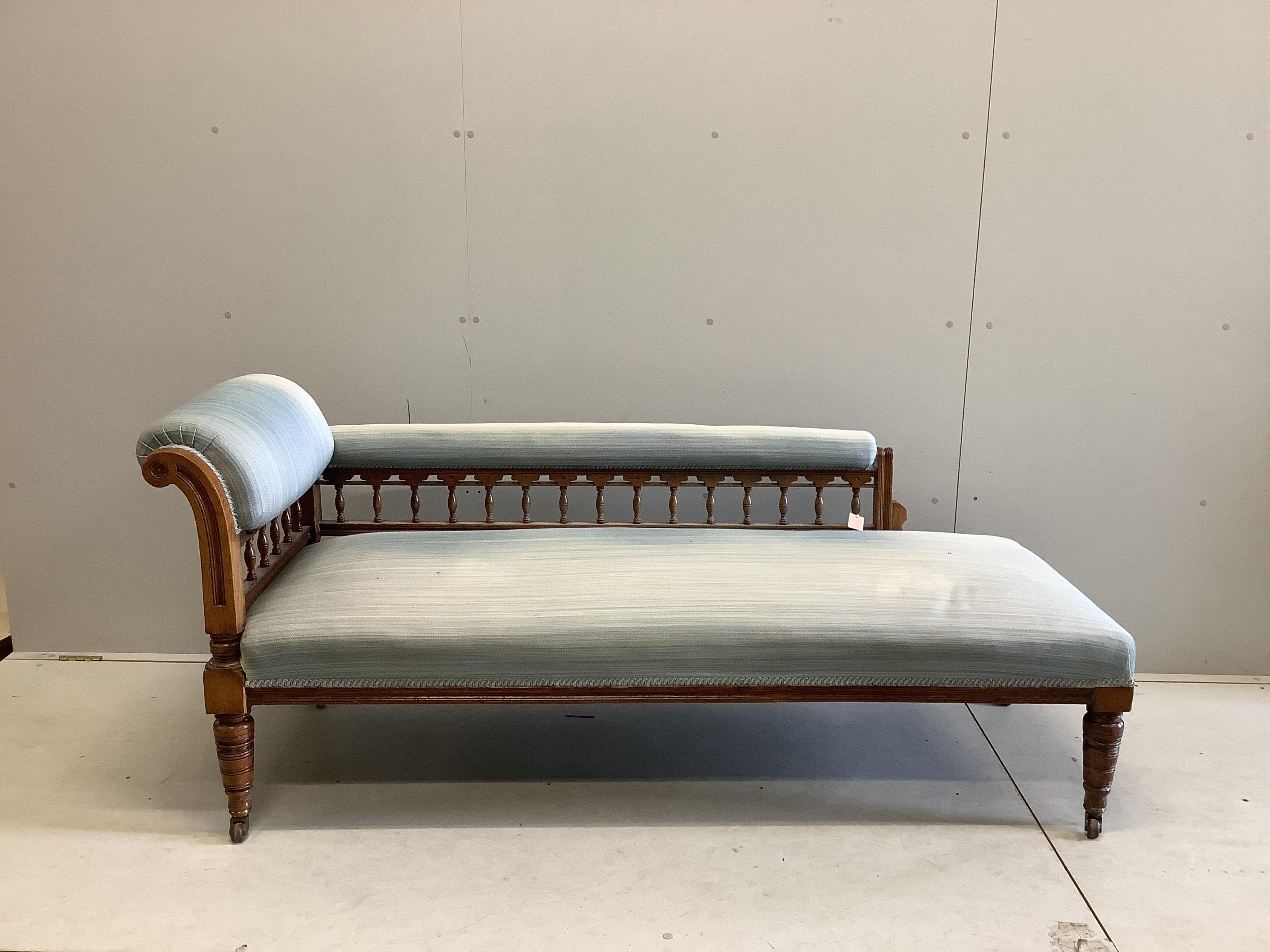 An Edwardian oak chaise longue, upholstered in green cord, on turned and carved legs fitted castors, width 184cm, depth 70cm, height 78cm. Condition - fair